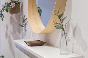 eine Vase mit Blumen auf einem Regal mit einem Spiegel in der Unterkunft Resort Villa Luny Gandia in Gandía