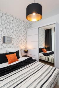 1 Schlafzimmer mit 2 Betten und einem Spiegel in der Unterkunft Apartament Tower II Premium - siłownia, sauna - ścisłe centrum by Kairos Apartments in Kattowitz