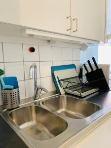 zlew kuchenny ze stali nierdzewnej z przyborami kuchennymi na blacie w obiekcie Stay Inn Apartments Norrmalm w Sztokholmie