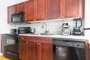 een keuken met houten kasten en een spoelbak bij Loop Studio w Gym Doorman nr L Parks CHI-300 in Chicago