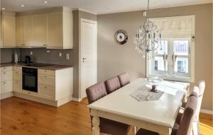 a kitchen with a table and chairs and a chandelier at 4 Bedroom Awesome Home In Strandvik 