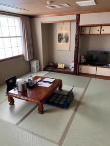 een woonkamer met een houten tafel in een kamer bij Shingu Central Hotel in Shingu
