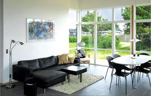 SønderbyにあるStunning Home In Juelsminde With 3 Bedrooms, Sauna And Wifiのリビングルーム(黒いソファ、テーブル付)