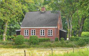 a red brick house in a field with trees at Holiday Home Hodde With Fireplace in Tistrup