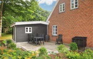 a patio with a table and chairs next to a building at Holiday Home Hodde With Fireplace in Tistrup +23 photos