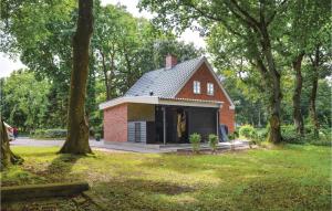 ein kleines rotes Backsteinhaus auf einem Feld mit Bäumen in der Unterkunft Gorgeous Home In Tistrup With Kitchen in Tistrup