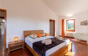 a bedroom with a large bed with orange pillows at Gorgeous Home In Montegabbione Tr With Kitchen in Montegabbione