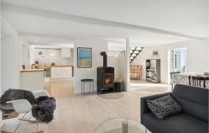 a living room with a couch and a stove at 4 Bedroom Stunning Home In Sams in Brundby