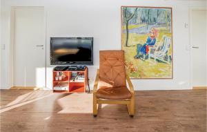sala de estar con silla y TV en Amazing Home In Augustenborg With Sauna en Asserballeskov