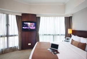 a hotel room with a bed with a laptop on it at Somerset Grand Hanoi in Hanoi