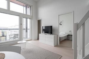 Dieses weiße Zimmer verfügt über ein Bett und einen TV. in der Unterkunft 2ndhomes Tampere "Metso" Loft Apartment - Brand New Top Floor Apt that Hosts 6 in Tampere