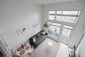 ein Wohnzimmer mit einem Sofa und einem Tisch in der Unterkunft 2ndhomes Tampere "Metso" Loft Apartment - Brand New Top Floor Apt that Hosts 6 in Tampere