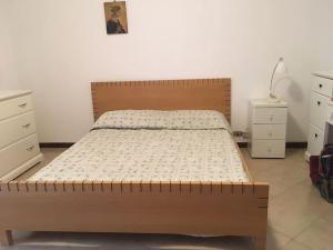 a bedroom with a bed with a wooden headboard at Vacation home Controra, Ginosa (TA) in Ginosa