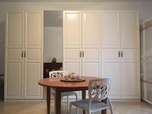 a dining room with a table and chairs and white cabinets at Vacation home Controra, Ginosa (TA) in Ginosa