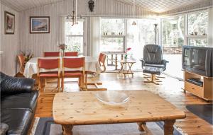 HelberskovにあるAmazing Home In Hadsund With 3 Bedrooms, Sauna And Wifiのリビングルーム(テーブル、テレビ付)