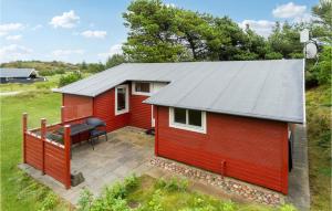 einen roten Schuppen mit einem Tisch und einer Terrasse in der Unterkunft Gorgeous Home In Fan With Kitchen in Fanø