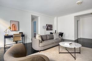 a living room with a couch and a table at Midtown 2br w doorman wd nr Central Park NYC-1246 in New York