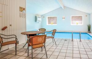 a patio with a table and chairs and a swimming pool at 8 Bedroom Nice Home In ster Assels in Sillerslev