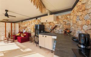 eine Küche und ein Wohnzimmer mit einer Steinmauer in der Unterkunft Stunning Home In Murcia With Swimming Pool in Murcia