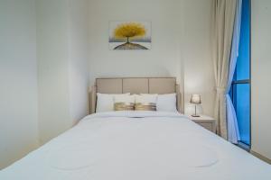 a bedroom with a white bed and a window at Dar Alsalam - Modern Apartment With Stunning Views in Dania 3 in Dubai