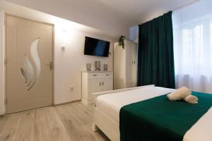 Un dormitorio con una cama y un televisor. en Best room, en Bucarest