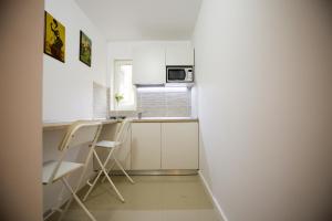Una pequeña cocina con gabinetes blancos y un fregadero. en Best room, en Bucarest