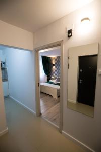 Habitación con espejo y dormitorio con cama. en Best room, en Bucarest