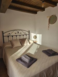 a bedroom with a large bed with towels on it at El Nido, Casa Rural in Casas del Castañar