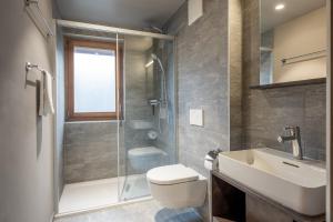 a bathroom with a toilet and a sink and a shower at SWISSPEAK Resorts Zinal in Zinal