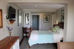 a bedroom with a bed and a table and a desk at 14 Mount Joy in Knysna