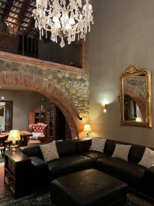 a living room with a black couch and a chandelier at Villa Sol Peralada Golf in Peralada