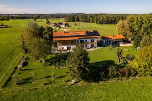 une vue aérienne sur une grande maison dans un champ dans l'établissement Fembacher Alm, à Seeon-Seebruck