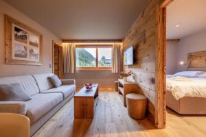 a living room with a couch and a bed at SWISSPEAK Resorts Zinal in Zinal