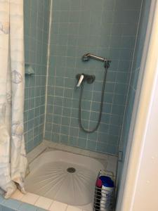 y baño con ducha y suelo de baldosa. en Maison Garesché, en Nieulle-sur-Seudre