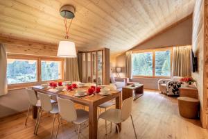a dining room and living room with a wooden ceiling at SWISSPEAK Resorts Zinal in Zinal