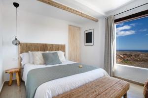 a bedroom with a bed and a large window at Apartamento La Higuera in Arrecife