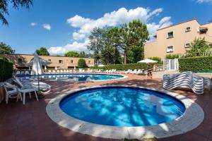 a large swimming pool with chairs and umbrellas at Appartamenti Massimiliano in Peschiera del Garda