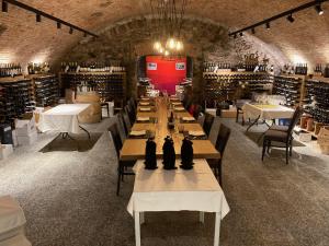 a wine cellar with a long table with bottles of wine at Hotel Ristorante Grotto Serta in Lamone