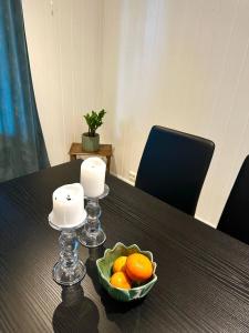 un tazón de naranjas y velas sobre una mesa en Hareidsvegen 145, 