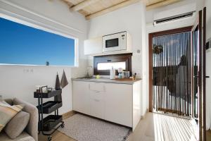 a small kitchen with a sink and a microwave at Apartamento La Higuera in Arrecife