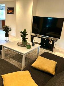 sala de estar con mesa y TV grande en Hareidsvegen 145, 