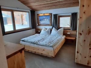 sypialnia z łóżkiem w pokoju z oknami w obiekcie Unterkoller Bauernhaus Chalet w mieście Bischofshofen
