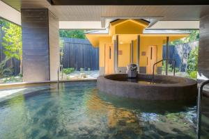 a bath tub in the middle of a house with water at UreshinoOnsen URESHINO YADOYA in Ureshino