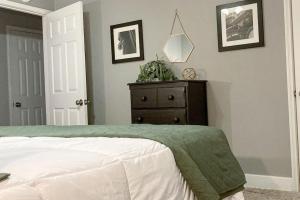 - une chambre avec un lit et une commode dans l'établissement Oak Forest Cottage, à Little Rock
