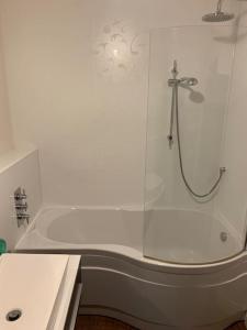 a white bathroom with a shower and a tub at The old post office in Golspie