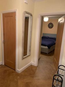een slaapkamer met een bed, een spiegel en een deur bij The old post office in Golspie