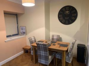 a dining room with a table and a clock on the wall at The old post office in Golspie