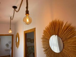 a mirror hanging on a wall with a fan at Casa La Chicuela in Lapeza