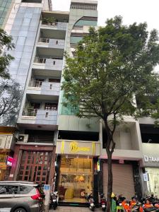 un albero di fronte a un palazzo alto di Mia Hotel ad Ho Chi Minh