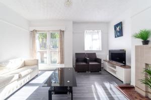 a living room with a couch and a tv at Hidden Gem, Bright 1BR flat wPatio in Lambeth in London